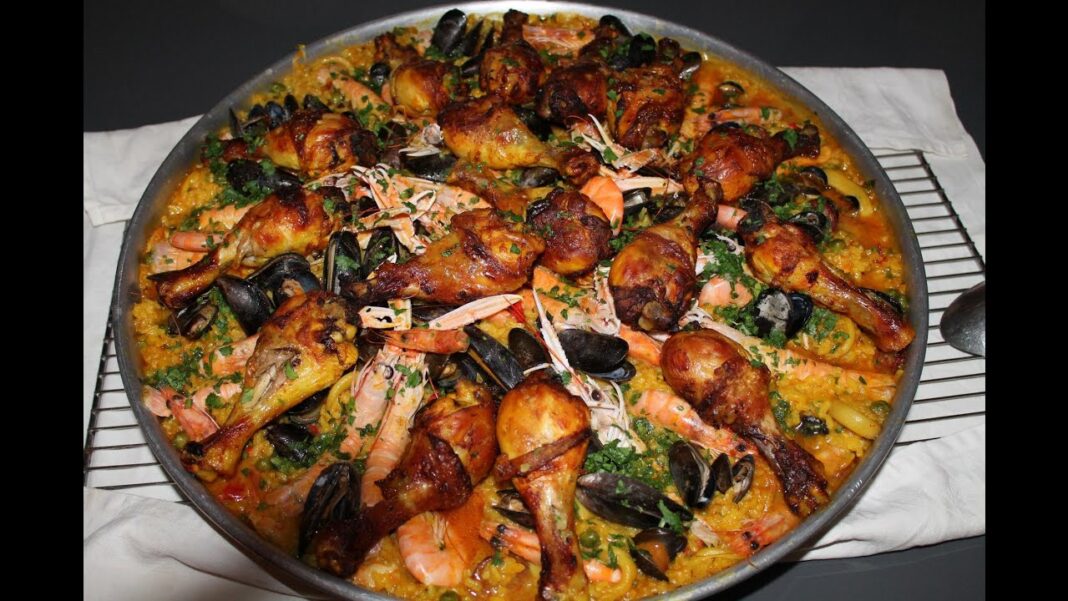 Découvrez le chef cuisinier Algérien Lamine Trabsi, spécialiste de la paella Paella espagnole avec poulet, fruits de mer et légumes colorés.