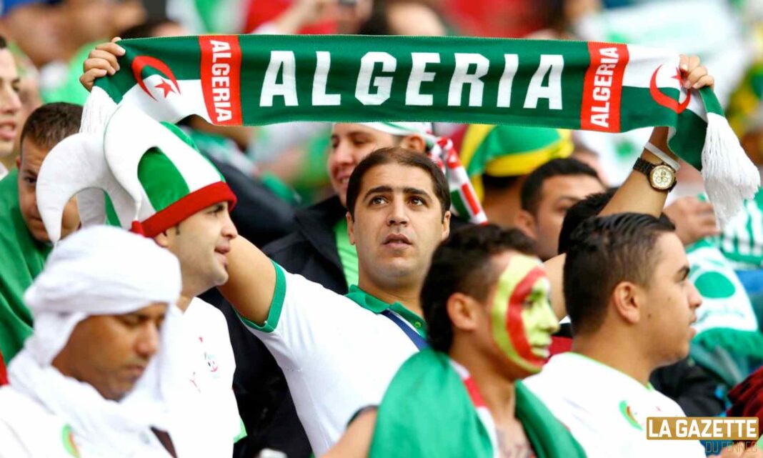 Les supporters Algériens optimistes pour la qualification au mondiale 2026 Supporters algériens avec drapeau et écharpe lors du match.