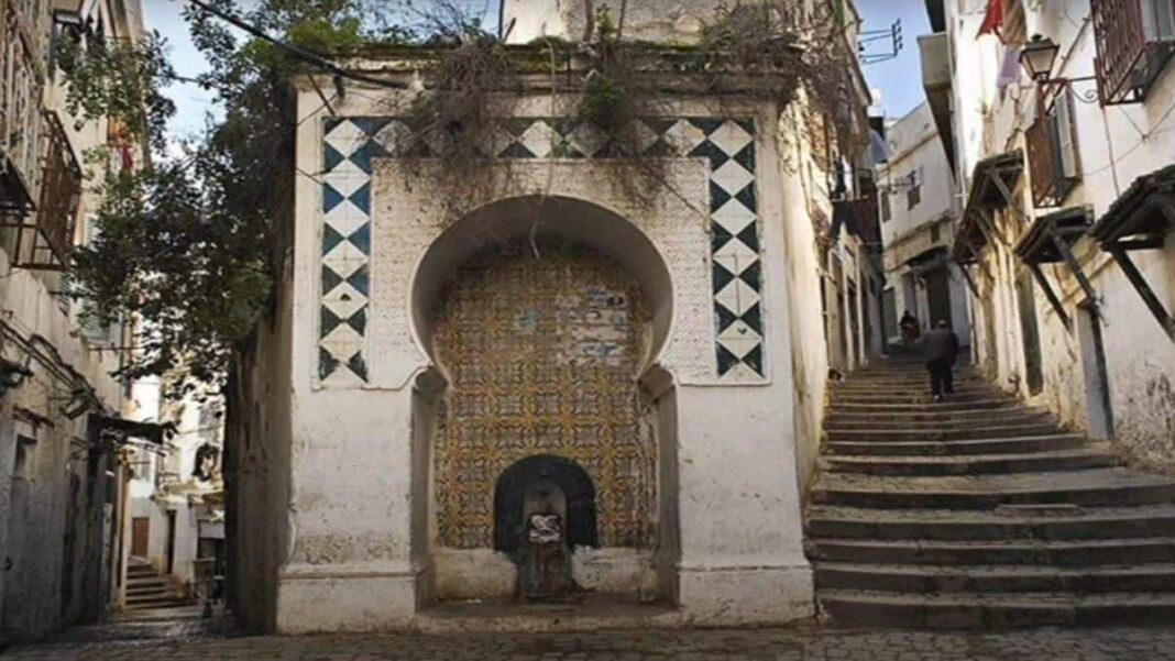 Culture et histoire : une délégation française en visite en Algérie Fresque murale en Algérie avec motifs géométriques et fontaine ancienne.