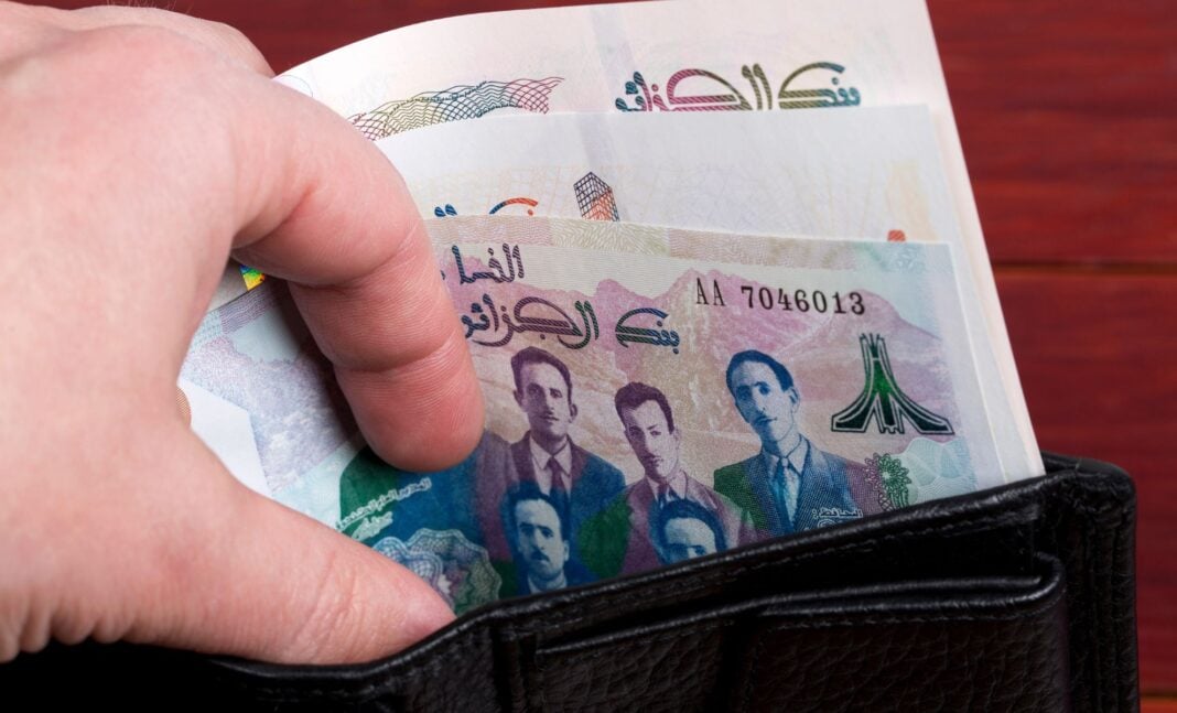 Dinar numérique algérien : En route vers l’univers de la cryptomonnaie et de la blockchain ? Découvrez la réponse. Femme mettant des billets de Dinar algérien dans un portefeuille.