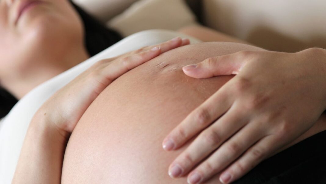 Agression : Deux présumés algériens portent la main sur une femme enceinte Femme enceinte touchant son ventre avec douceur.