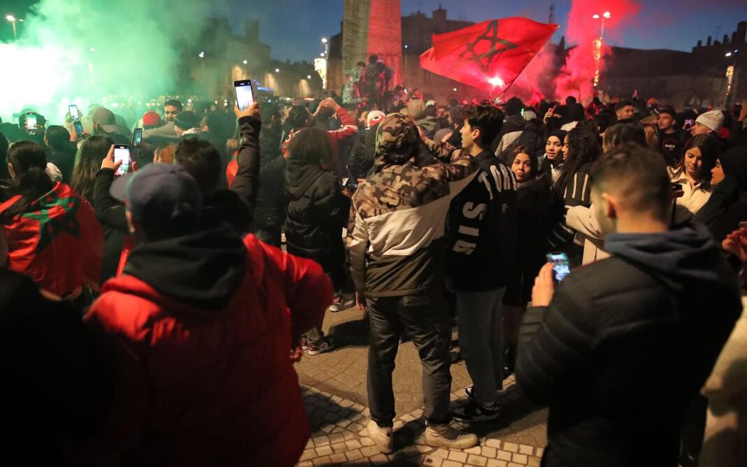 Maroc France : plus de 100 personnes placées en garde à vue à Paris Foule de supporters avec drapeau marocain lors d'une manifestation nocturne.
