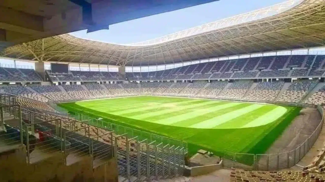 Nouveau stade de Baraki : voici la date du match d’ouverture Stade de football moderne à Baraki avec terrain vert et sièges.