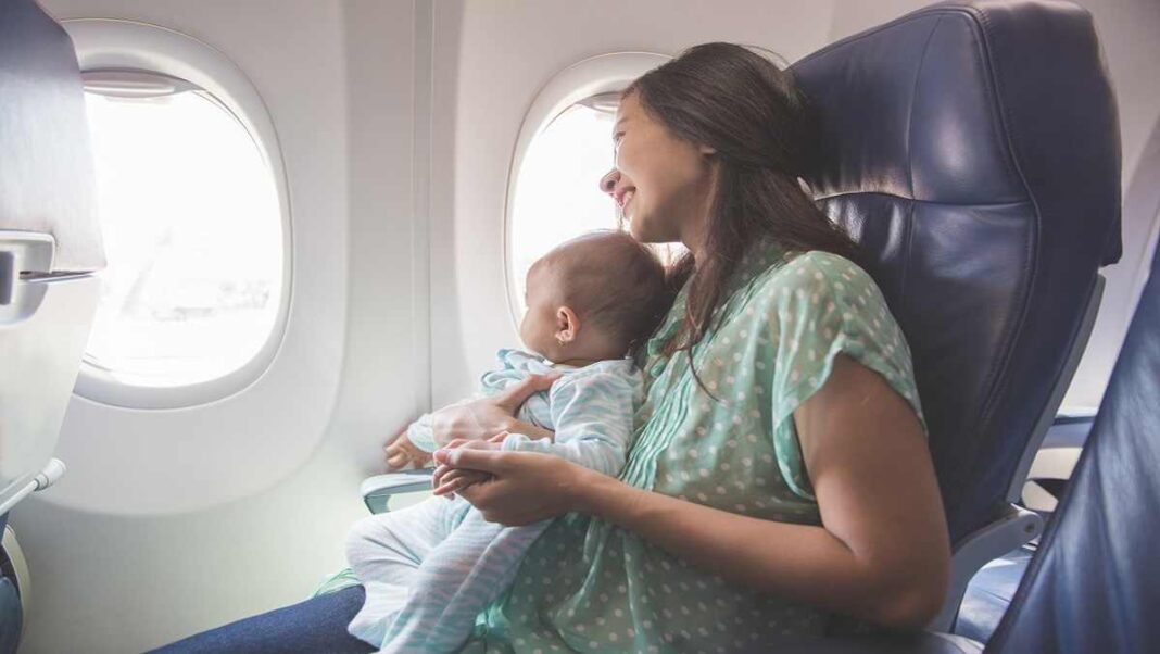 Voyage avec bébé en avion Mère et bébé souriants dans l'avion, confort et sécurité en voyage.