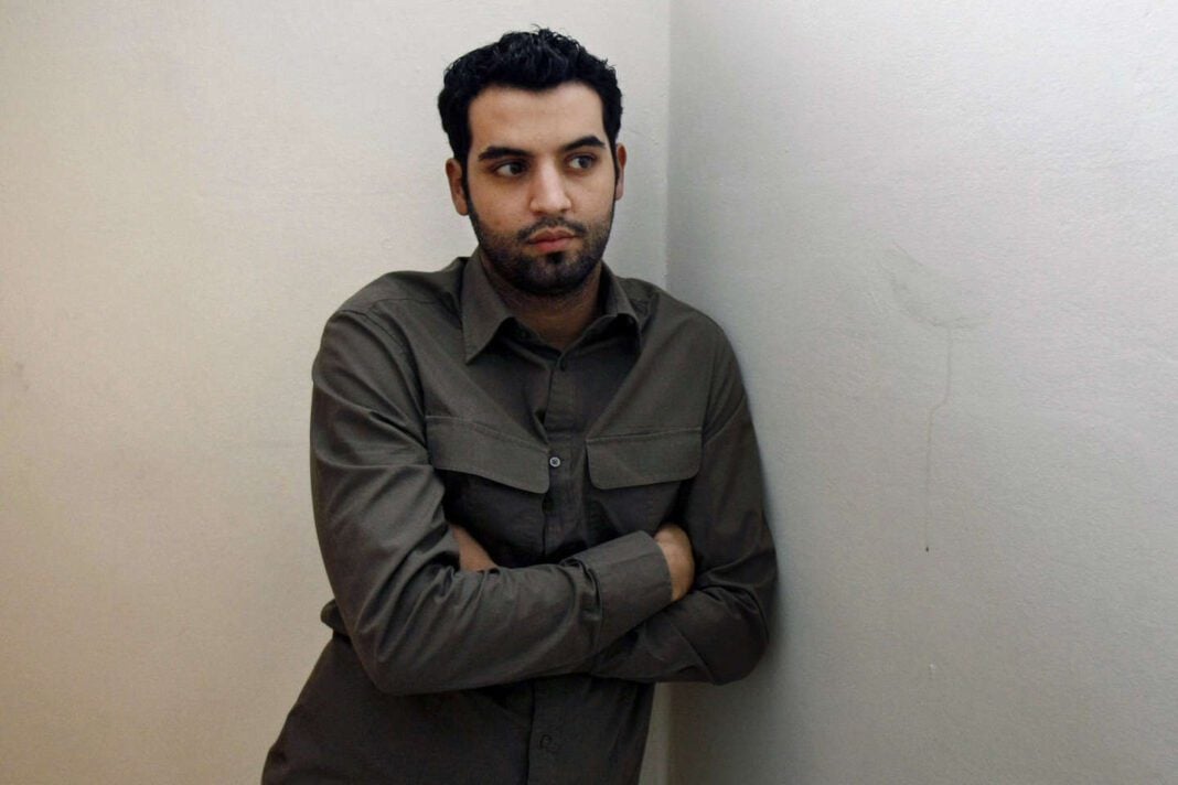 Yassine Belattar, homme pensif, contre un mur blanc.