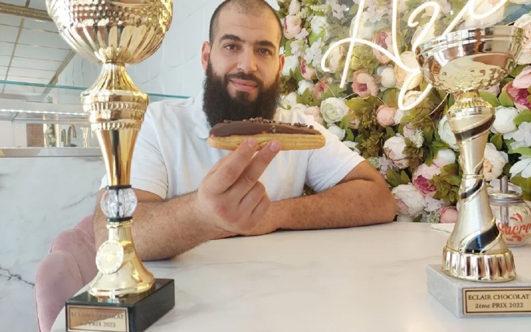 Incroyable ! Un Algérien est l’un des meilleurs pâtissiers de France Pâtissier algérien avec trophées et gâteau lors d'une compétition.