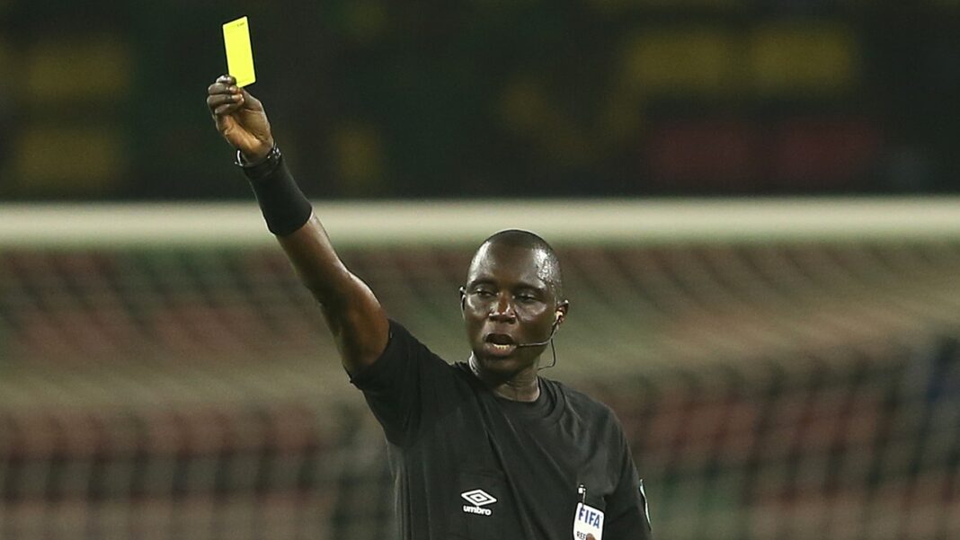 Mondial 2022 : Gassama retiré de la liste des arbitres par la FIFA Arbitre Gassama montrant un carton jaune lors d'un match de football.