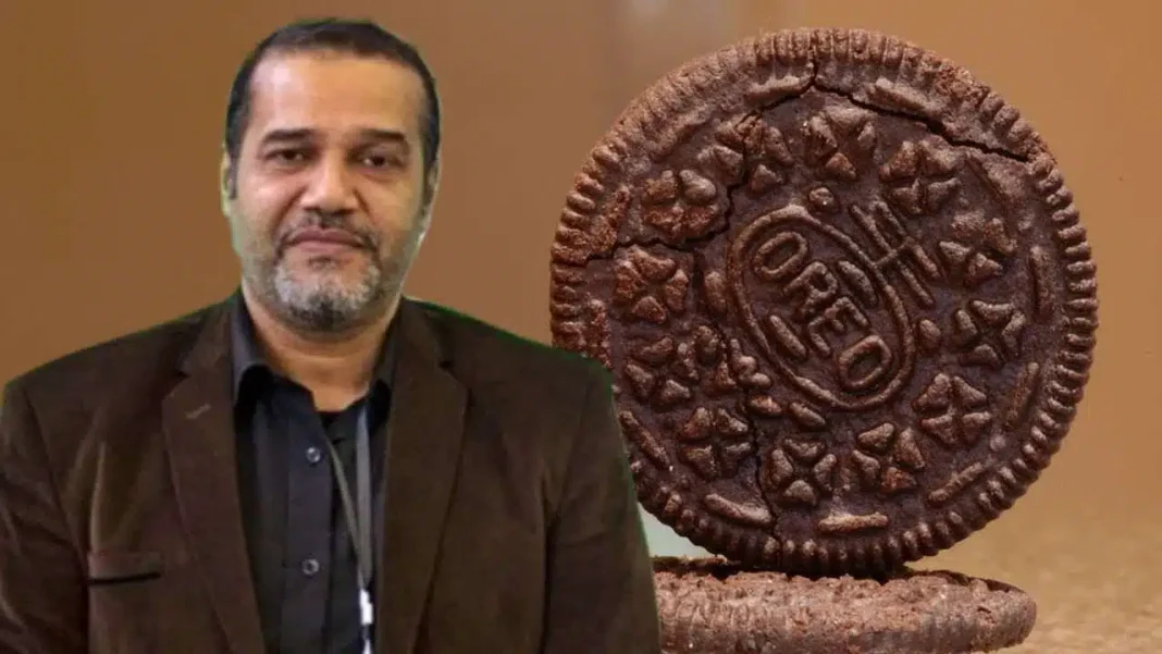 Urgent! l’APOCE alerte sur des biscuits non halal vendus en Algérie Homme avec biscuits Oreo non halal en arrière-plan.