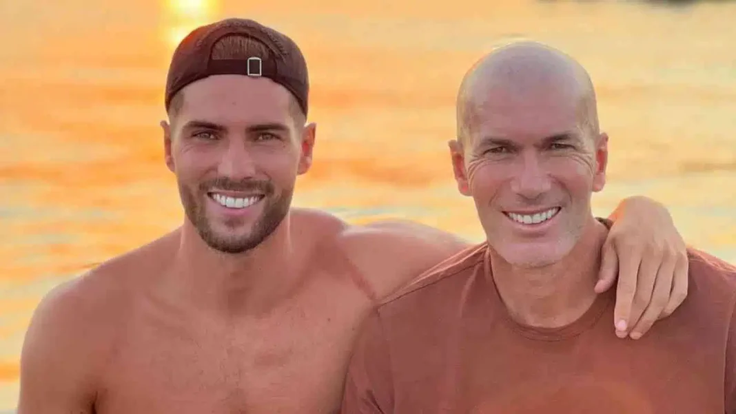 Officiel/Équipe d’Algérie : Zidane une nouvelle fois dans la ligne de mire Deux hommes souriants, bras autour, à la plage au coucher du soleil.