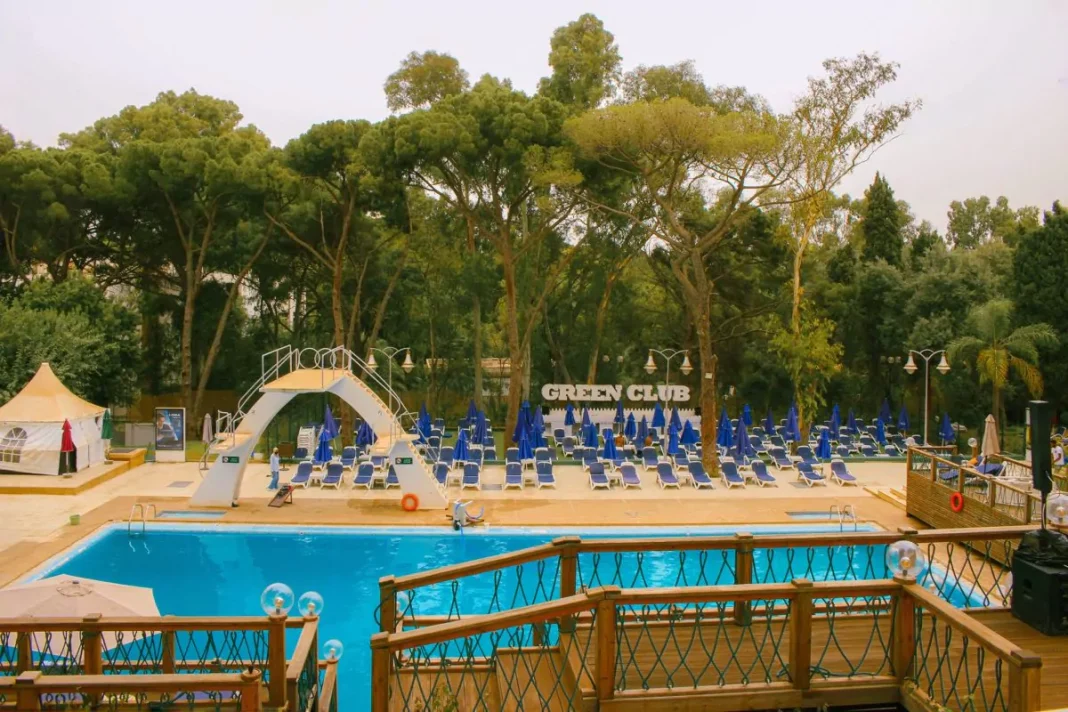 Bon à savoir: Découvrez le Top 3 des meilleures piscines d’Alger Piscine du Green Club avec chaises longues et parasols bleus.