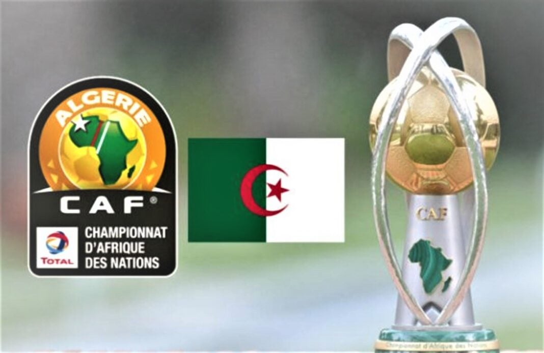 CHAN 2023 : La Libye se retire-t-elle de la dance ? Réponse dans les lignes à suivre. Trophée de la CAN 2023 avec drapeau algérien et logo CAF.