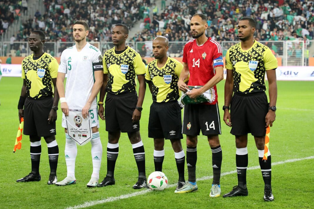 Arbitre et joueurs lors du match Algérie-Niger Arbitre et joueurs alignés avant le coup d'envoi du match CHAN 2023.