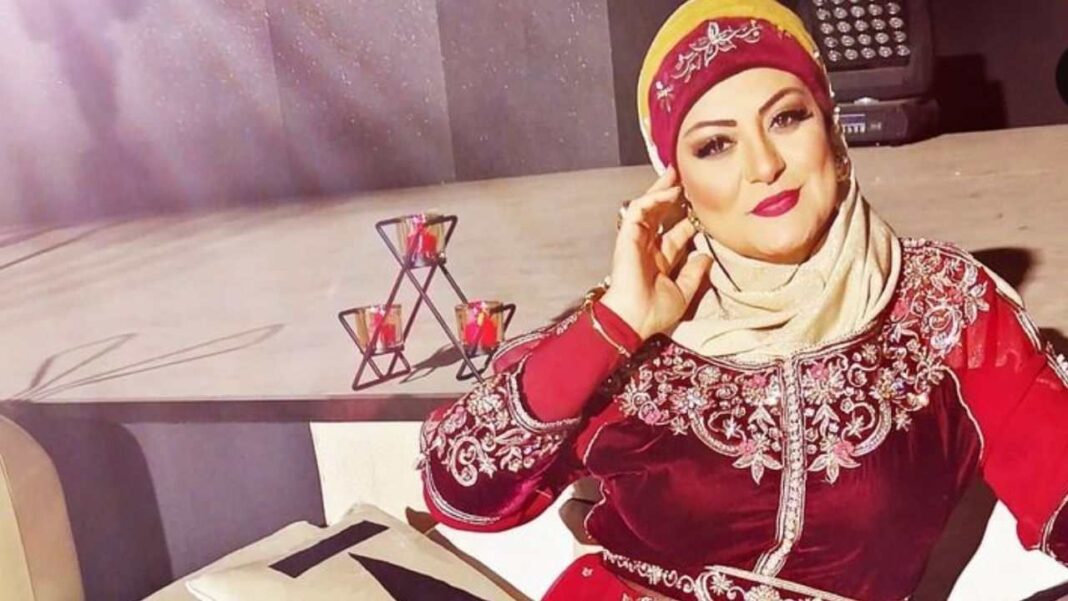 Asma Djermoune portant un hijab rouge et une tenue traditionnelle élégante.