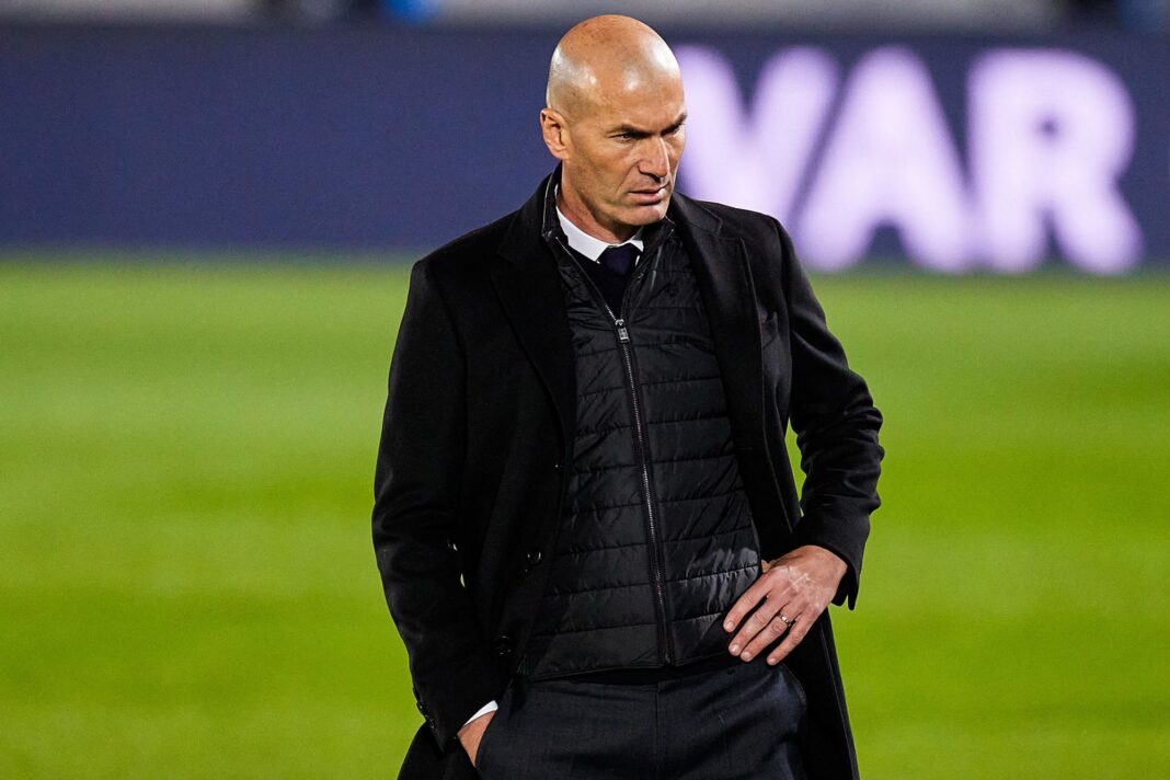 Zidane lors d'un match de football Zidane, entraîneur de football, sur le terrain en pleine réflexion.