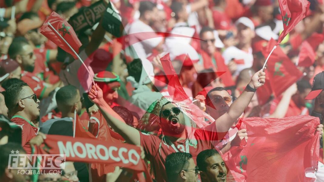Supporters marocains en fête avec drapeaux et banderoles lors d'un match de football.