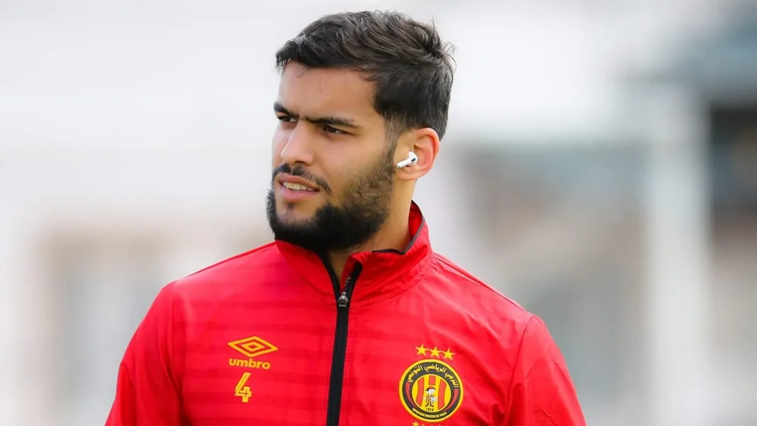 Le RC Lens et l’ES Troyes font une cour assidue à ce joueur algérien pour s’offrir ses services. Footballeur algérien portant maillot rouge et écouteurs.