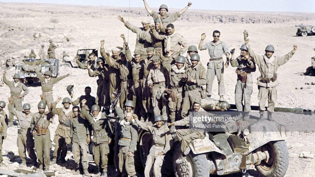 Armement: Voici la vraie raison de la réception du chef de la junte d’Alger à l’Elysée. Groupe de soldats militaires dans le désert avec véhicules militaires en arrière-plan.