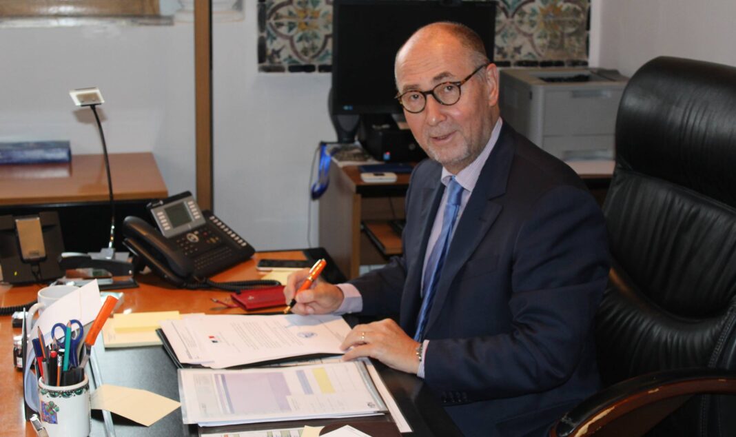 Ambassadeur de France en Algérie au bureau L'ambassadeur de France en Algérie dans son bureau, en train de signer des documents importants.