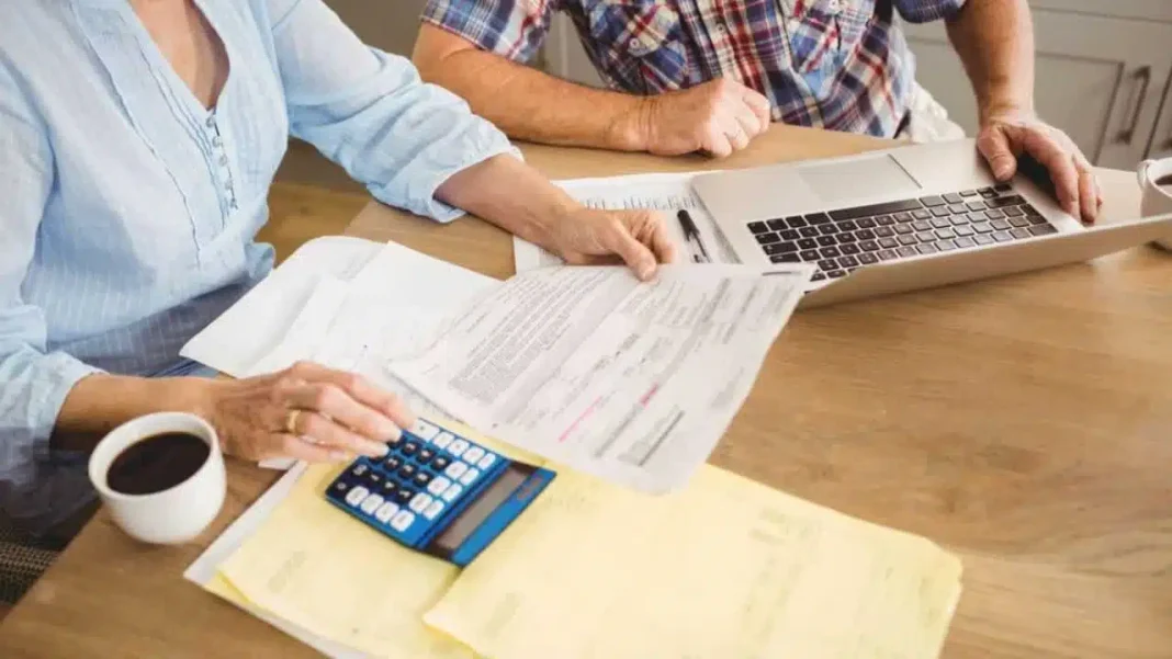 Voici comment les Algériens en France peuvent calculer leur pension de retraite Deux personnes calculant leur pension de retraite avec documents et ordinateur.