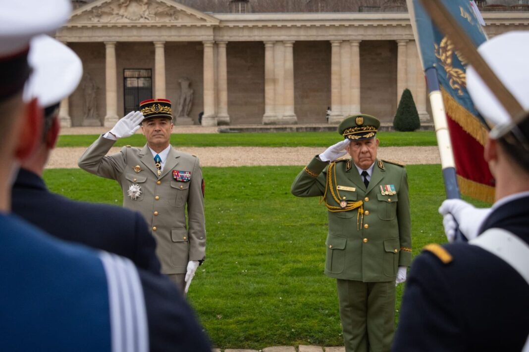 Officiers saluant lors d'une cérémonie militaire devant un bâtiment historique.