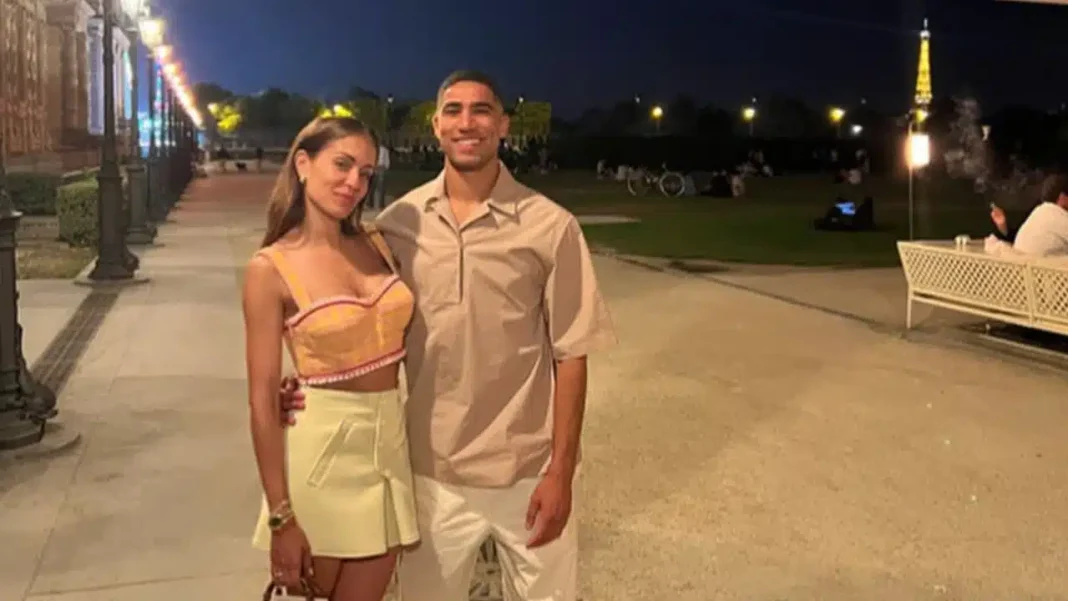 Jeune femme et homme souriants lors d'une promenade nocturne dans un parc.