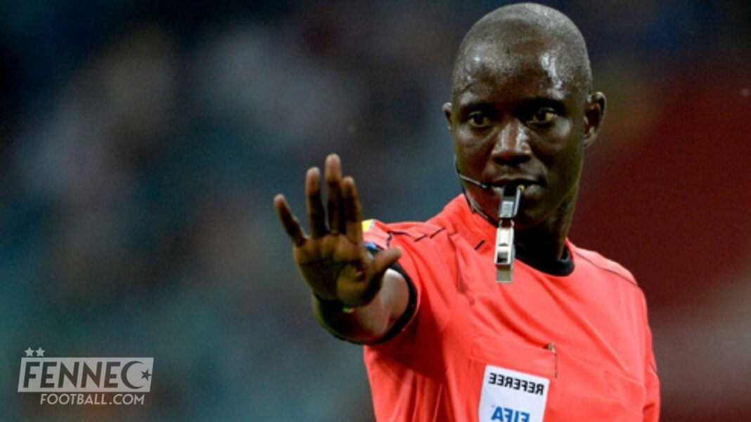 Algérie : L’arbitre Gassama n’ira pas à la retraite Arbitre Gassama avec sifflet, signalant une faute lors d'un match de football.