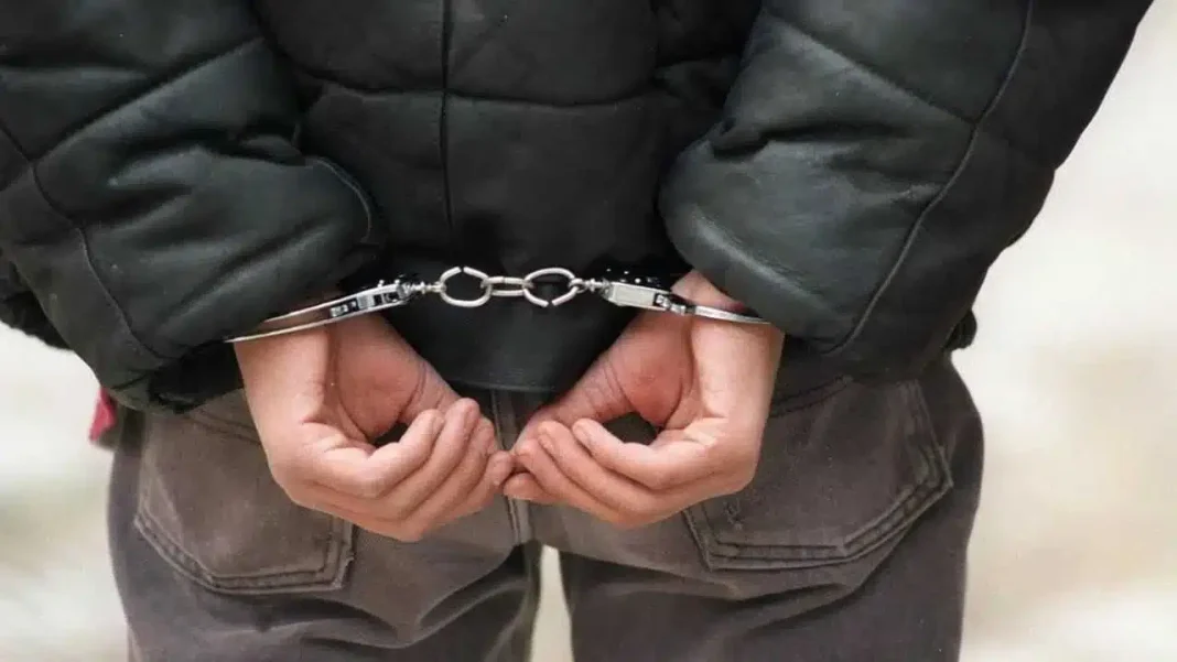 France: Un Algérien sans-papiers essaie d’étrangler son enfant Personne en garde à vue avec menottes, mains derrière le dos.