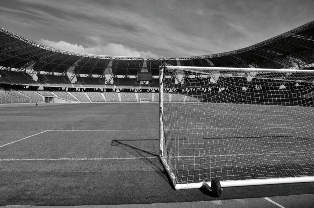 Drame à Alger : décès d’un joueur en plein match Stade de football vide avec but en premier plan en Algérie.
