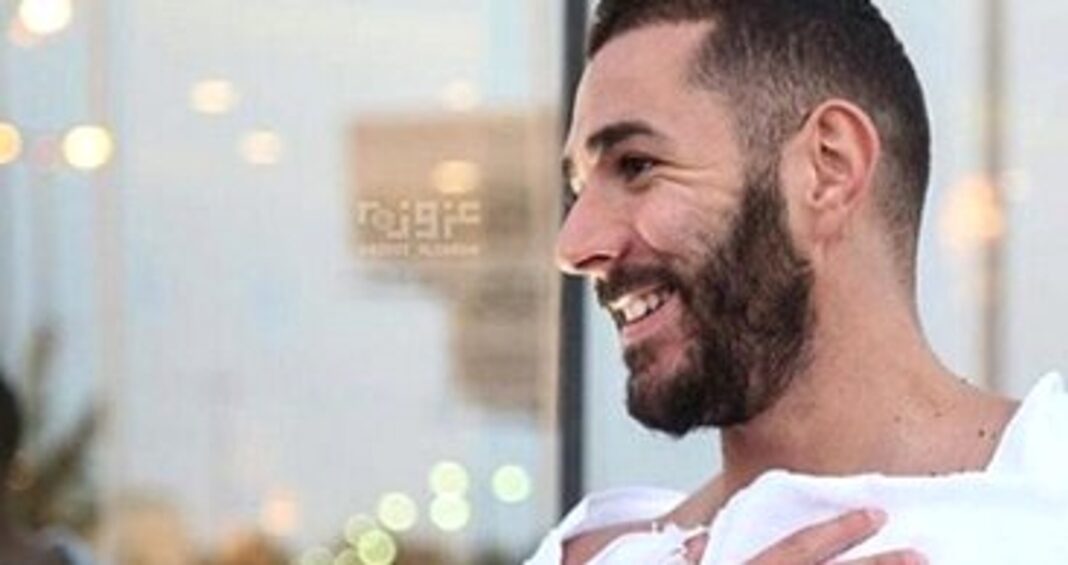 Un membre de la famille de Benzema arrêté Homme souriant avec barbe, en intérieur lumineux.