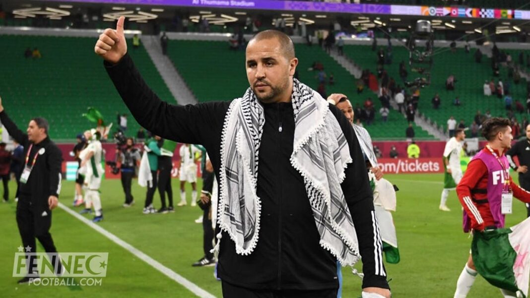 Algérie-Sénégal : Voyageons au cœur du parcours des deux entraineurs finalistes du CHAN 2022, Bougherra et Thiaw. Homme en tenue noire avec foulard, saluant lors d'un match de football.