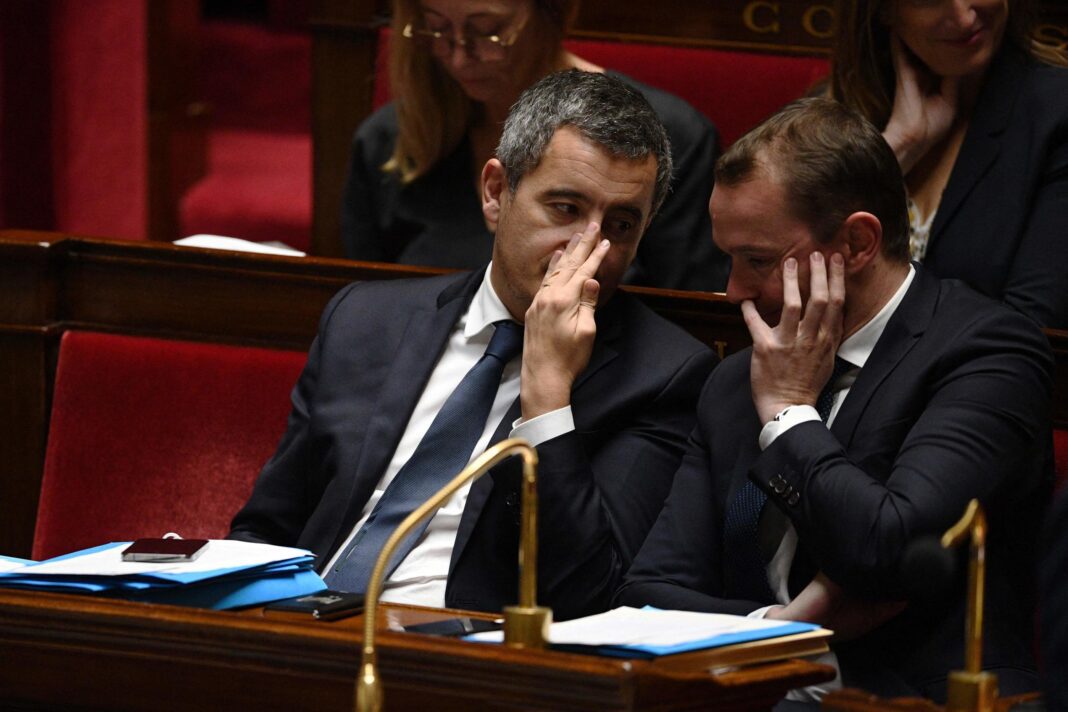 Nouvelle loi sur l’immigration : le gouvernement français resserre les mailles. Deux députés en discussion lors d'une session parlementaire.