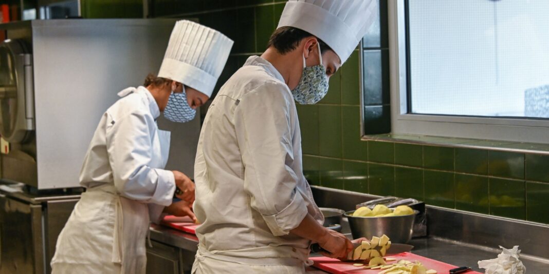 Restauration/France: Vers la facilitation des recrutements hors des frontières européennes Cuisiniers en formation portant des masques en cuisine professionnelle.
