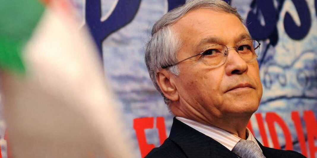 Coup de tonnerre ! Un ex-ministre algérien soupçonné de corruption par le Qatar Homme d'affaires âgé portant des lunettes et costume lors d'une conférence.