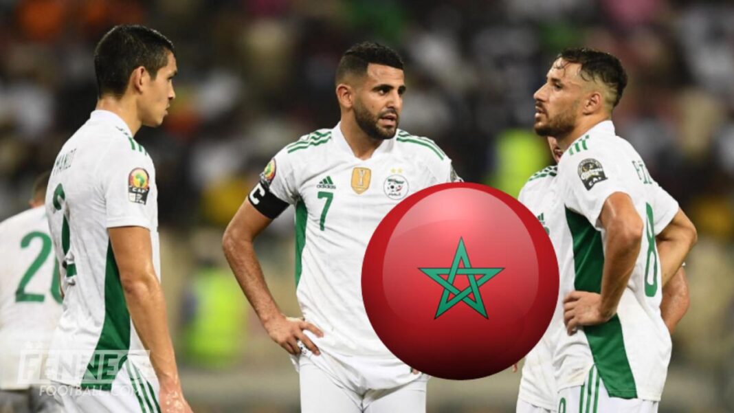 Joueurs algériens discutant lors d'un match de football.