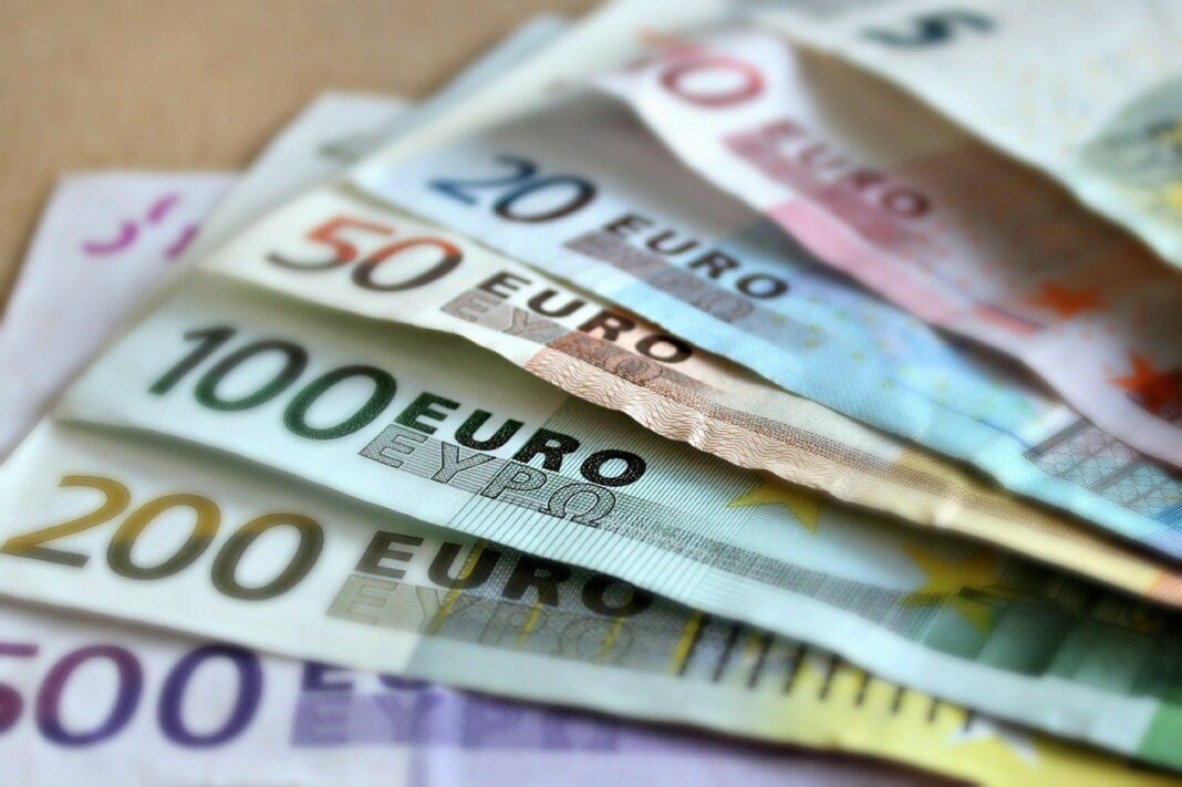 Billets en euros de différentes valeurs sur une surface en bois.