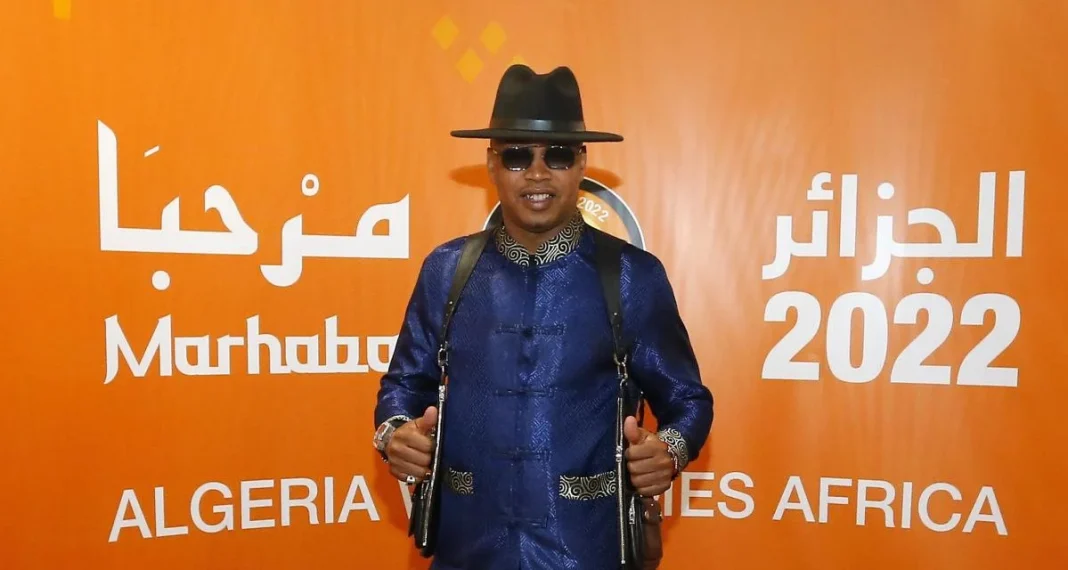 Person en tenue élégante à l'événement Marhaba 202 Homme portant un costume bleu, chapeau noir et lunettes de soleil lors de l'événement Marhaba 2022.