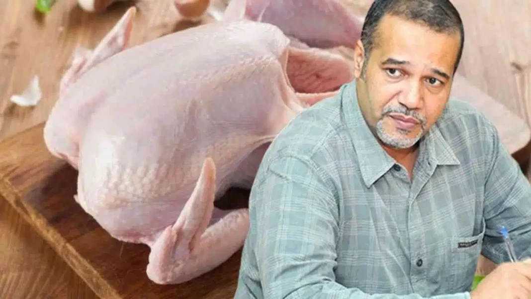 Homme en train d'examiner une poule dans un marché.