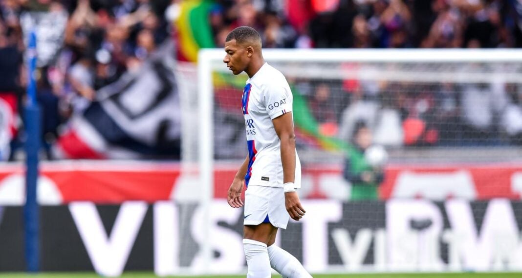 Kylian Mbappé sur le terrain, concentré, lors d'un match de football.