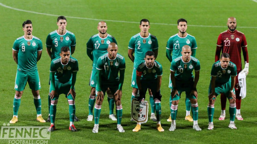 L'équipe nationale d'Algérie lors d'un match, en maillots verts et avec le capitaine en avant-plan.