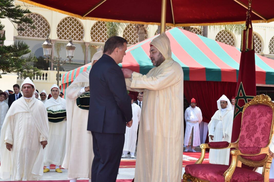 Homme en costume et homme en tenue traditionnelle lors d'une cérémonie au Maroc.