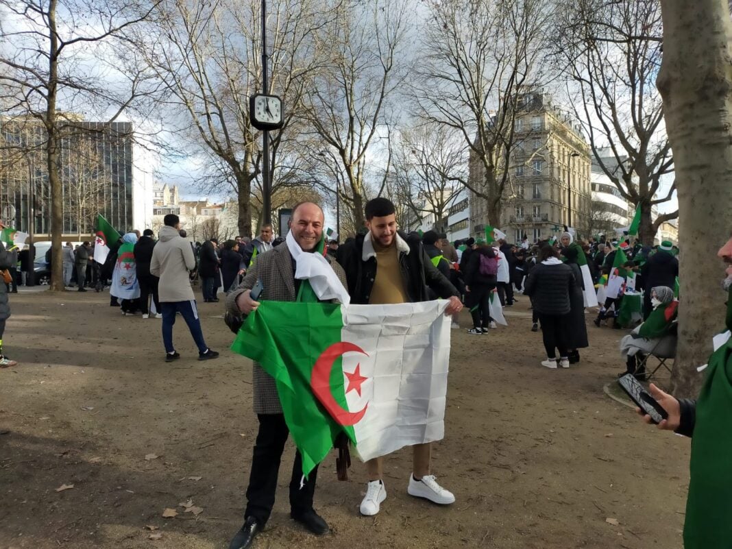 Coup de Tonnerre ! Le préfet de Paris lance une insulte à l’Algérie Hommes tenant un drapeau algérien lors d'une manifestation en plein air.