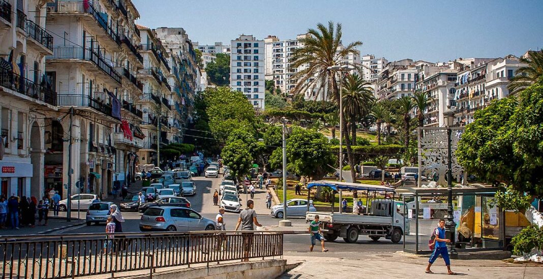 Liberté économique : L’Algérie occupe une place catastrophique. Rue animée avec voitures, piétons et bâtiments en Algérie.