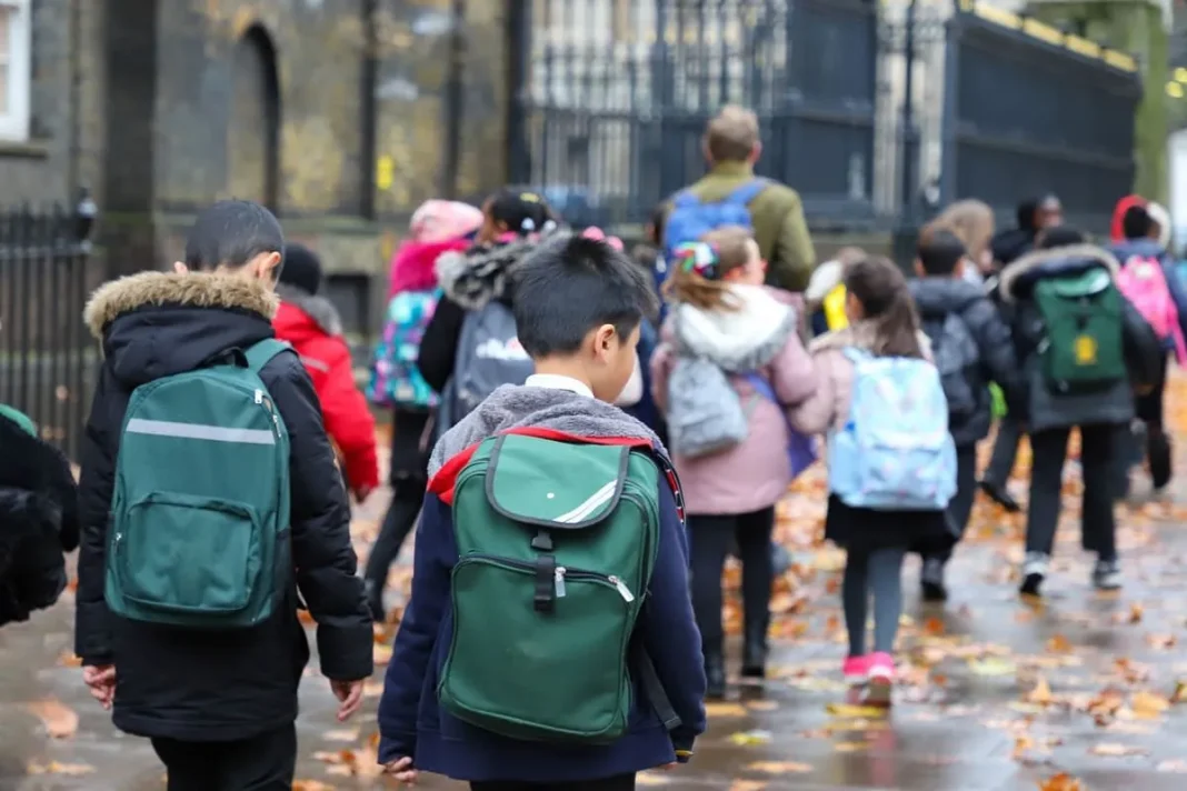 Groupe d'enfants avec sacs à dos en route vers l'école à Oran.