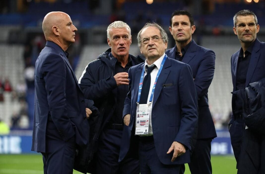 Présidents de la FFF en discussion Hommes en costume lors d'une réunion de la FFF sur le terrain.