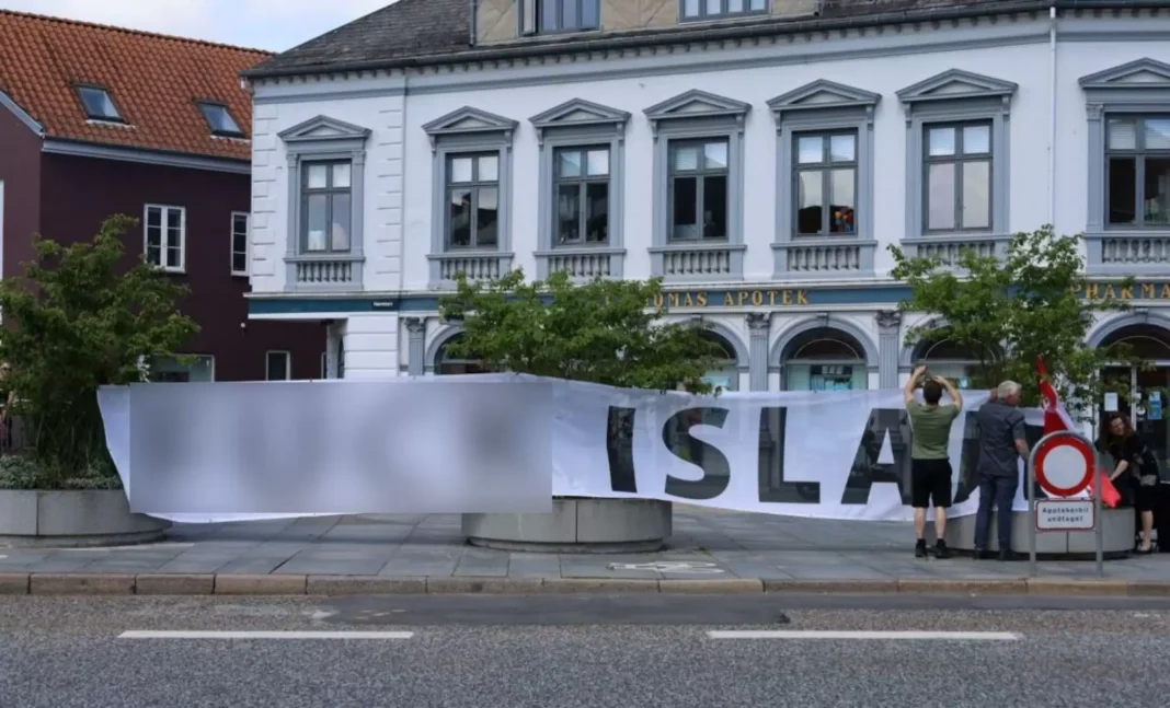 Sacrilège ! Un Coran est brûlé devant l’ambassade de Turquie au Danemark le premier jour de ramadan Manifestation devant l'hôtel avec bannière et drapeaux, protestation contre le sacrilège.