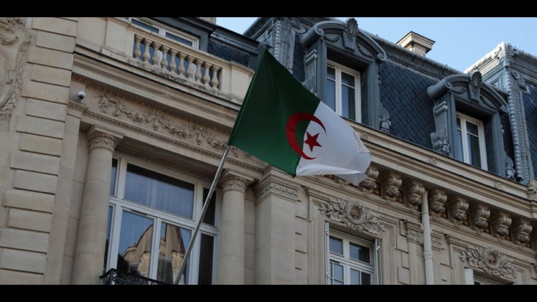 Drapeau algérien flottant devant un bâtiment ancien à Paris.