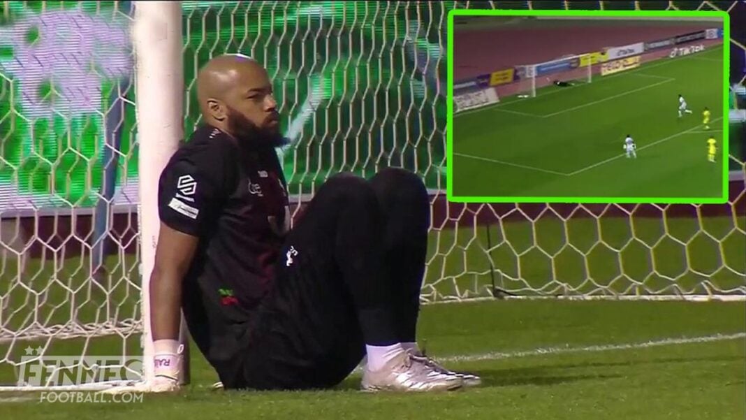 Raïs Mbolhi lors d'un match de football Raïs Mbolhi assis sur le terrain, regardant le match, dans un stade de football.