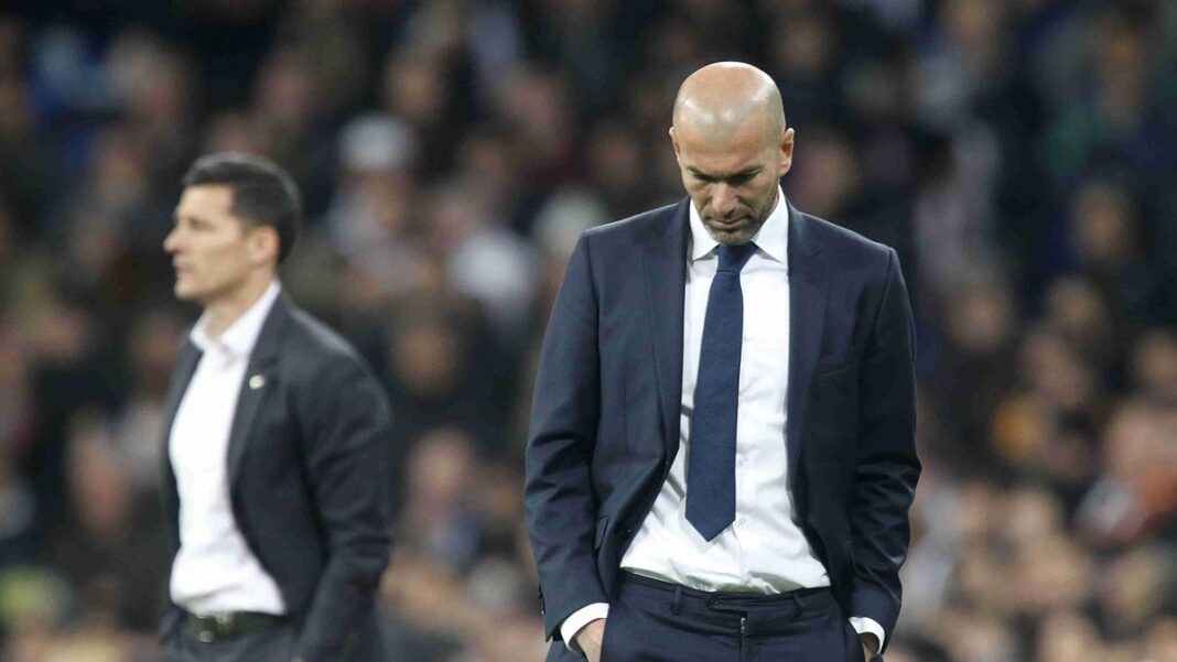 Zidane en pleine réflexion Zidane, entraîneur de football, en pleine réflexion lors d'un match.