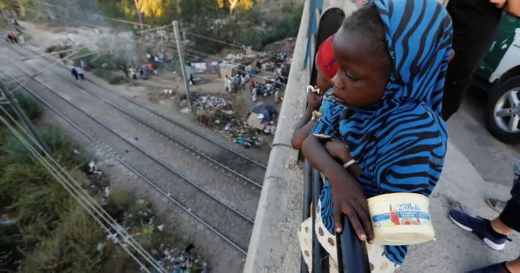 Algérie : ce couple de réfugiés africains se montre généreux et laisse les internautes sans voix. Jeune réfugié africain observant la voie ferrée depuis un pont.