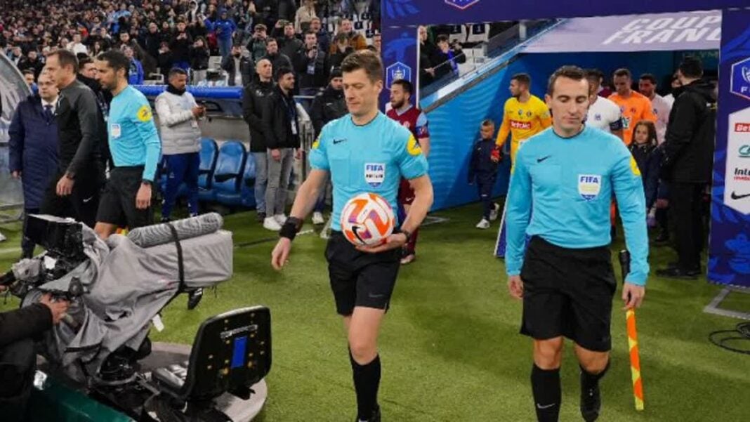 Chasse au Ramadan en France : un arbitre français pousse un énorme coup de gueule Arbitres en tenue bleue sur le terrain de football avant un match.